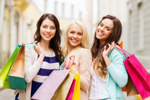 shopping and tourism concept - beautiful girls with shopping bag