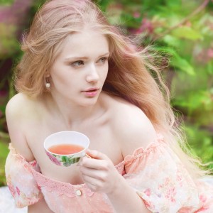 Beautiful woman with flowering tree drinking tea. Beauty young g