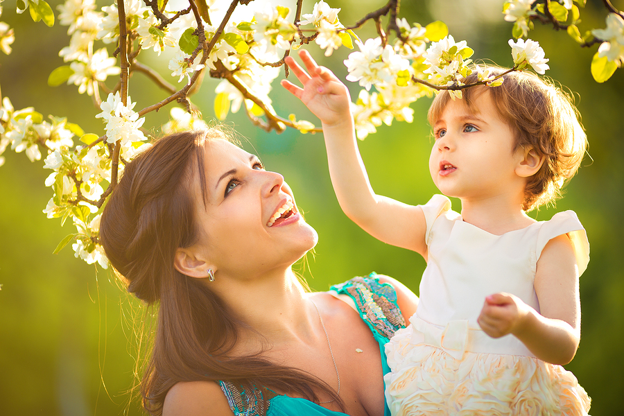 Happy Woman And Child In The Blooming Spring Garden.child Kissin