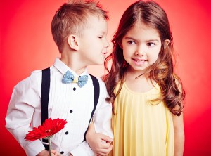 Cute little boy whispering something to his girlfriend