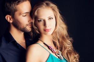 Portrait of a beautiful young couple in love posing at studio ov