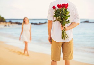Young Couple in Love, Man holding surprise bouquet of roses for