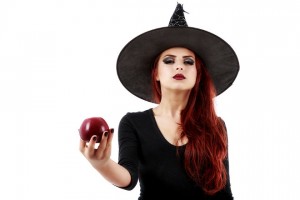 Tricky witch offering a poisoned apple Halloween theme