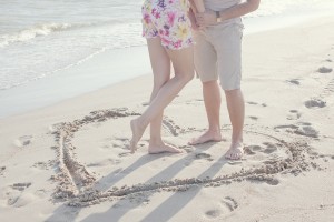 A Heart Shape Drawn In The Sand. Couple Standing Inside Heart Pi