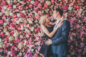 Happy Loving couple in the studio flowers wall