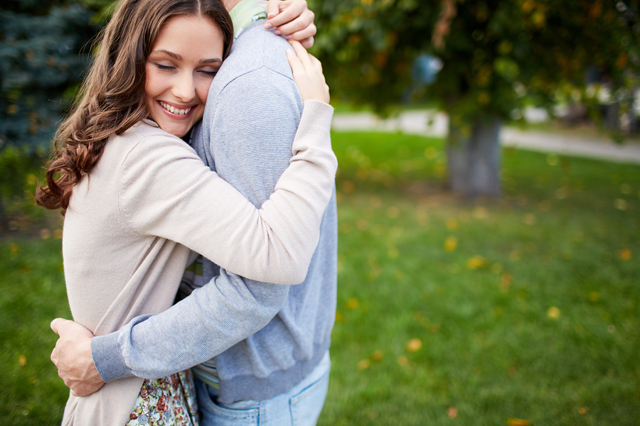 Happy girl embracing her boyfriend in park