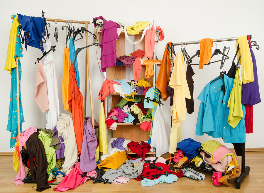 Untidy cluttered woman wardrobe with colorful clothes and access