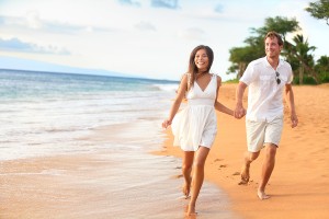 Beach couple walking on romantic travel honeymoon having fun run
