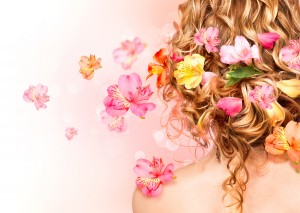 Hairstyle with colorful flowers. Beautiful healthy curly hair de