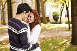 Love and affection between a young couple at the park in autumn