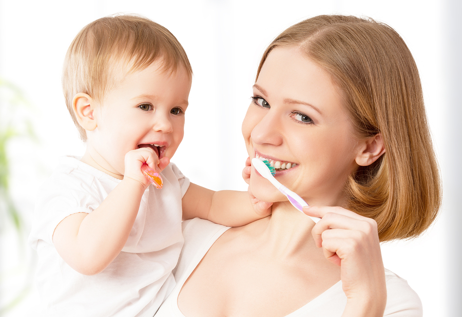 Mother And Daughter Baby Girl Brushing Their Teeth Together