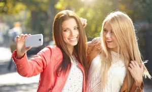 Friends making selfie. Two beautiful young women making selfie