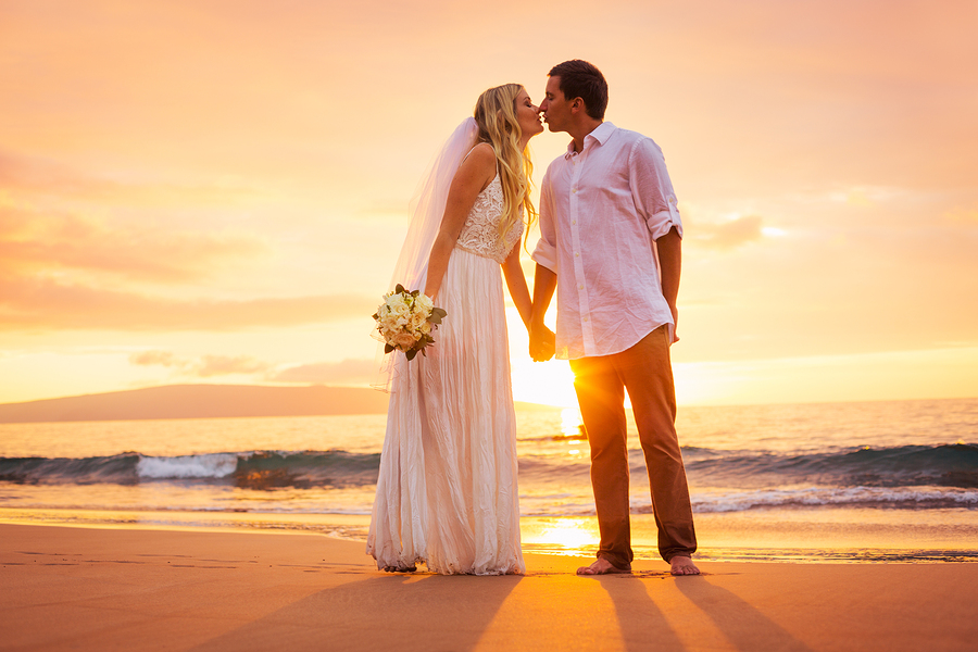 Just married couple kissing on tropical beach at sunset, Hawaii