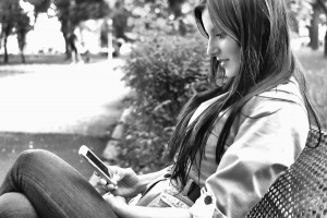 Pretty young woman using mobile phone internet