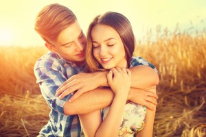 Beauty Couple relaxing on wheat field together. Happy girlfriend