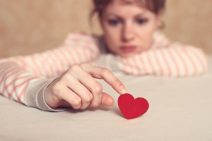 Sad Girl Is Holding Heart Symbol By Her Finger