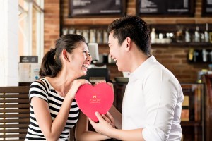 Asian couple, woman and man, having date in coffee shop with red