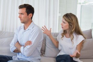 Unhappy couple having an argument in living room at home