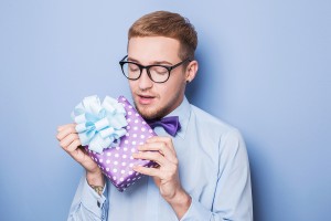 Closeup portrait of happy excited young man with colorful gift b