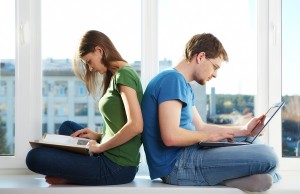 Photo of man and woman sitting back to back and doing their work