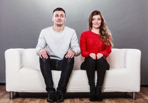 Shy Woman And Man Sitting On Sofa. First Date.